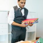 A focused businessman organizing folders in a modern office setting.