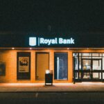 Exterior view of a Royal Bank building at night with glowing facade lights.